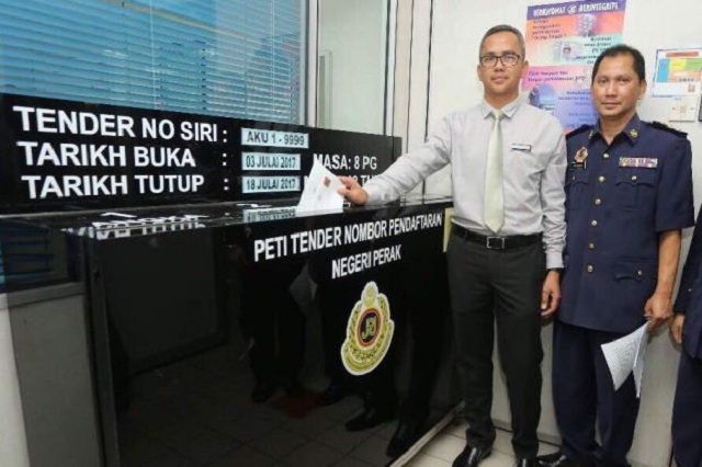 The Star Mohd Zawawi Zakaria (left) and Perak JPJ vehicle license registration unit chef Ridzuan Rayman (right) with the bidding box.
